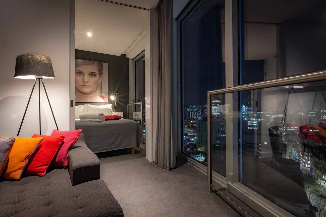 Staying Cool's maxi apartment living area and first bedroom with beautiful nighttime city views