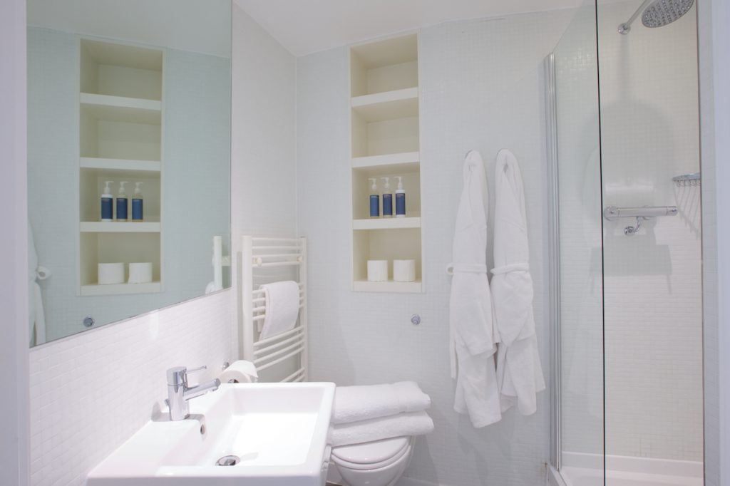 Shower room with bathrobes, towels and toiletries in a studio apartment at Rotunda