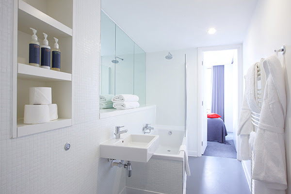 Bathroom showing large bathtub, fluffy towels and bathrobes which all make for a great hotel stay after a long day at the NEC