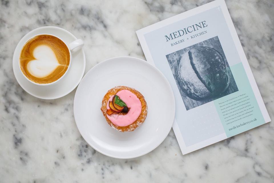 Doughnut and coffee with menu on table at Medicine Bakery, Birmingham