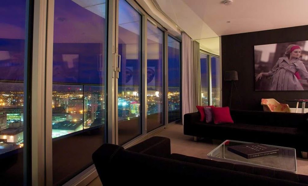 Staying Cool's Rotunda penthouse at night with colourful city views.