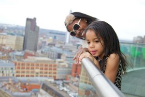 Two children enjoying the view from staying cool's family-friendly Birmingham hotel penthouse balcony