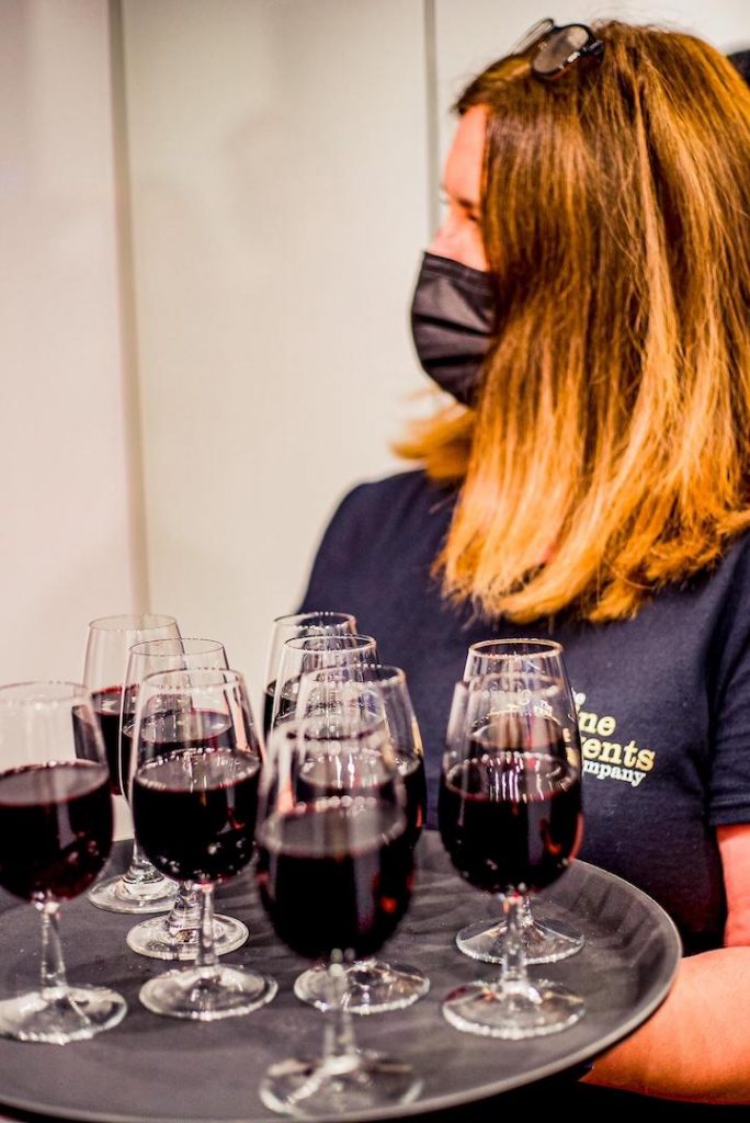 Alex Nicholsen-Evans holding tray of red wine ready for guests of the Wine Staycation event at Staying Cool's Rotunda Aparthotel