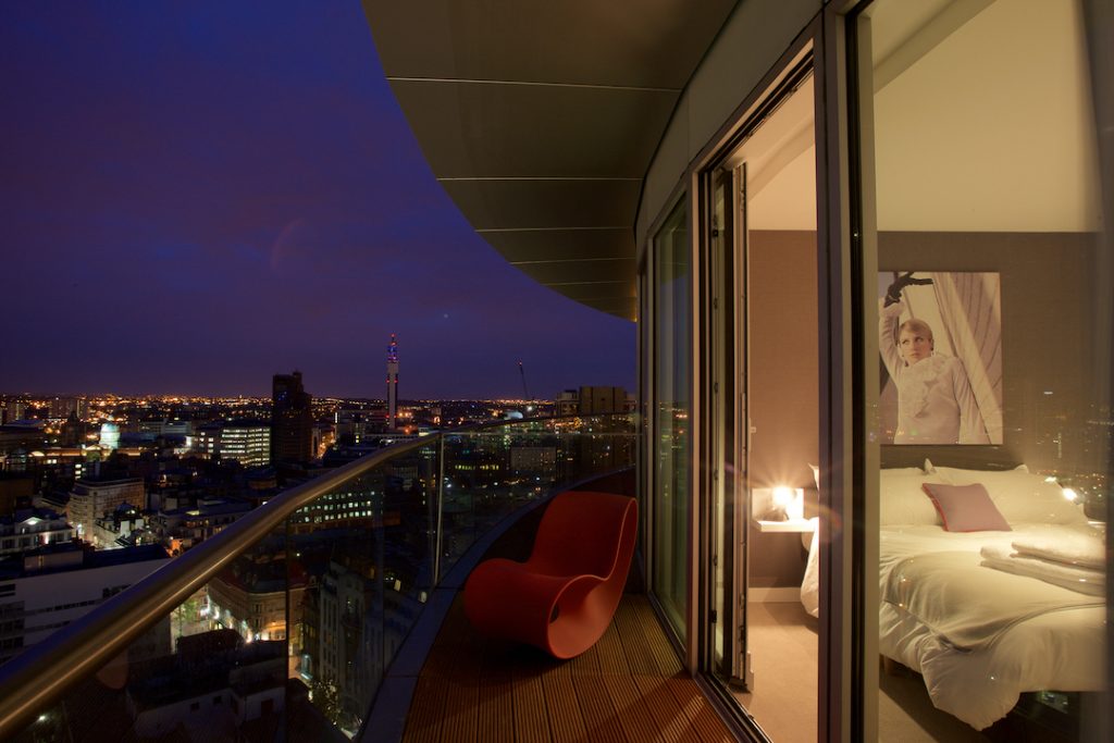 Night time city views from Staying Cool's rotunda apart hotel penthouse apartment with interior views of the bedroom too.