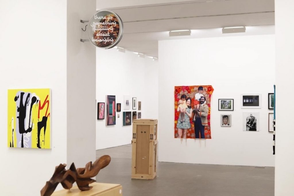 The interior of Birmingham's Ikon Gallery at Brindlayplace with artwork on the walls and a sculpture in the forefront. 