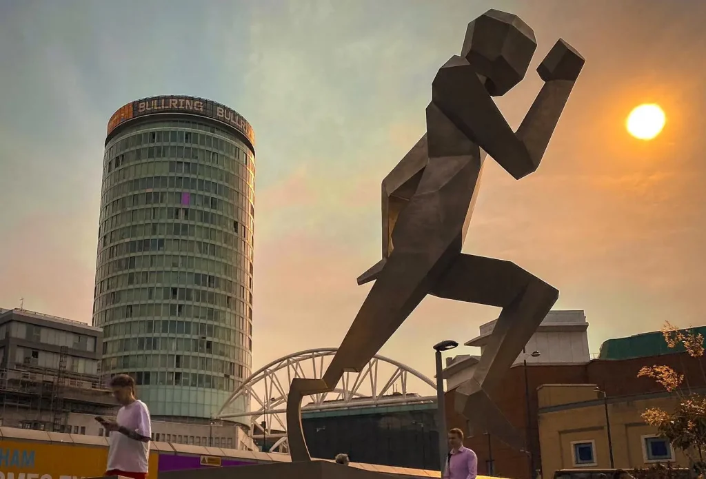 The "One Giant Leap For Humankind" statue by artist Jacob Chandler, commissioned for Birmingham 2022 Commonwealth Games Festival is located outside Birmingham New Street station, next door to Staying Cool at Rotunda.